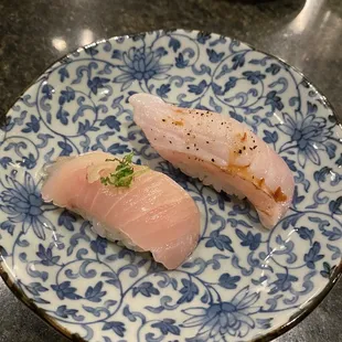 two pieces of sushi on a blue and white plate