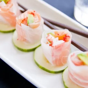 a plate of sushi rolls with chopsticks