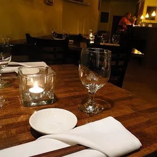 a table setting with wine glasses, plates and utensils