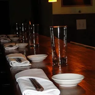 a long wooden table with plates and utensils