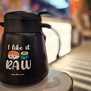 a black coffee pot with sushi written on it