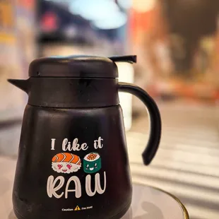 a black coffee pot with sushi written on it