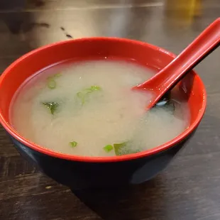 a bowl of soup with chopsticks