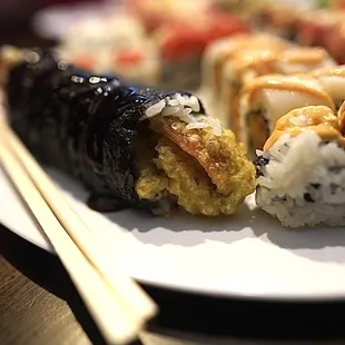a plate of sushi and chopsticks