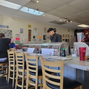a man behind the counter at a sushi restaurant