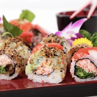 a variety of sushi rolls on a red plate