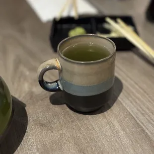 a cup of green tea and chopsticks
