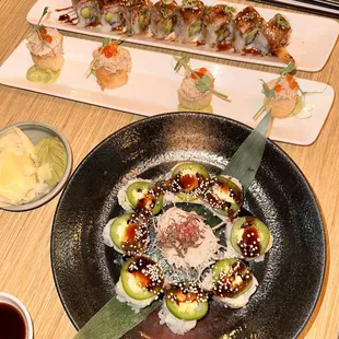 a plate of sushi rolls and a bowl of sauce