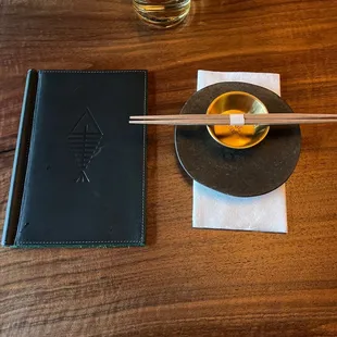 a wooden table with chopsticks and a glass of water