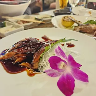 a plate of sushi with a purple flower