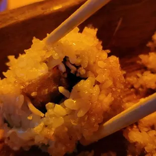 a close up of a sushi with chopsticks