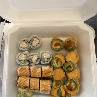 various types of sushi in a styrofoam container