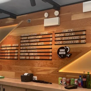 a restaurant counter with a menu on the wall