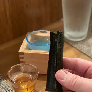 a person holding a piece of sushi