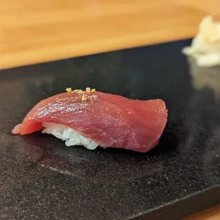 a piece of raw tuna on a black plate