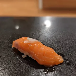 a piece of salmon on a black plate