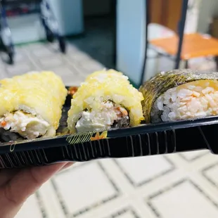 a person holding a tray of sushi