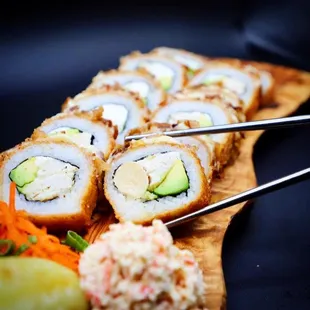 a plate of sushi with chopsticks