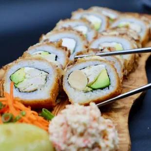 a plate of sushi with chopsticks