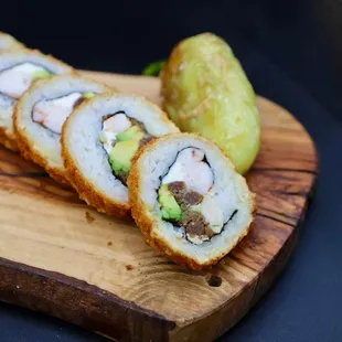 three pieces of sushi on a wooden cutting board