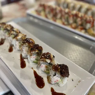 two plates of sushi with sauce on them