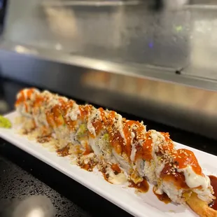 a long roll of sushi on a white plate