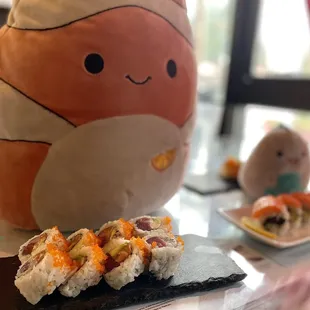 a stuffed animal and a plate of sushi