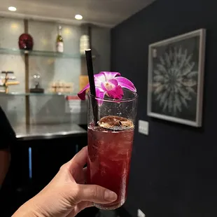 a person holding a glass of cocktail