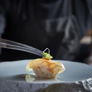 a sushi dish being served on a plate