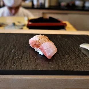 a sushi being prepared on a cutting board