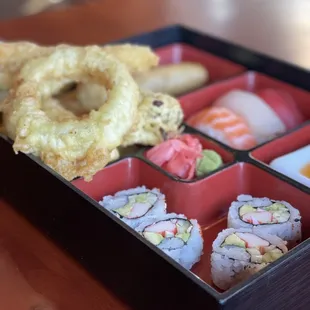 a bento box with a variety of sushi