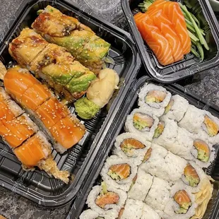 a variety of sushi in plastic containers