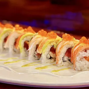 Sunny Roll: 8 pieces. Salmon, tuna, and yellowtail, topped with crab meat, avocado, ikura (salmon roe), and wasabi sauce.