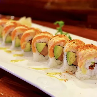 Six Flags Roll: 8 pieces. Pepper tuna and avocado, topped with seared salmon, nanami togarashi (Japanese chili pepper), and wasabi sauce