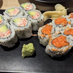 a variety of sushi on a black plate