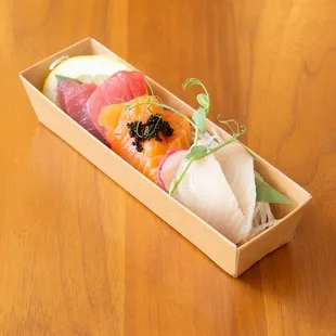 a box of sushi on a wooden table