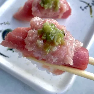 two pieces of tuna on a stick