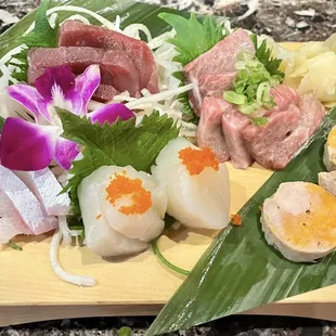 Toro, Scallop, Yellow Tail Belly, and Monk Fish Liver adorned with an orchid flower.