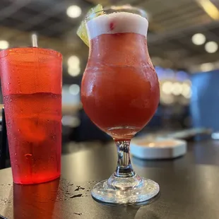 a red drink and a glass of water