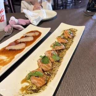 two rectangular plates of sushi on a table