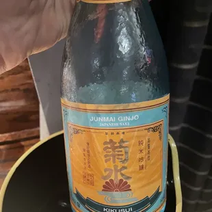 a person holding a bottle of sushi