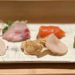 a variety of sushi on a white plate