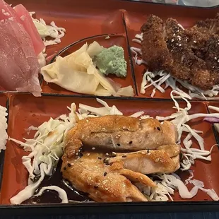 a bento tray with rice, meat, and vegetables