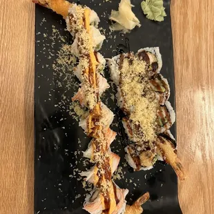 two pieces of sushi on a black plate