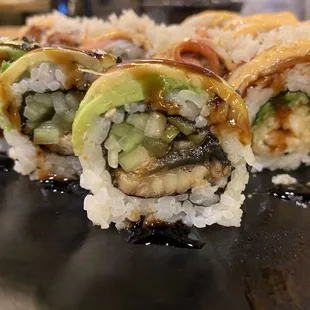 Dragon roll (avocado on top, eel inside). Shaggy dog behind.