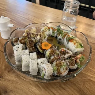 a plate of sushi rolls on a wooden table