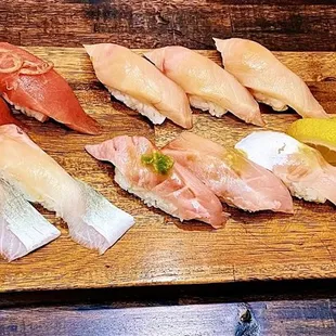 a wooden cutting board with different types of sushi