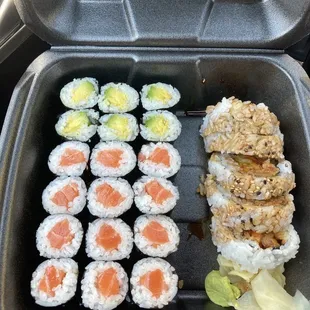 a container of sushi and a plate of salmon