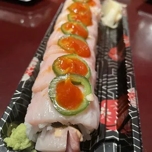 a long sushi roll with various toppings
