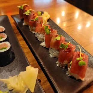 two plates of sushi on a wooden table